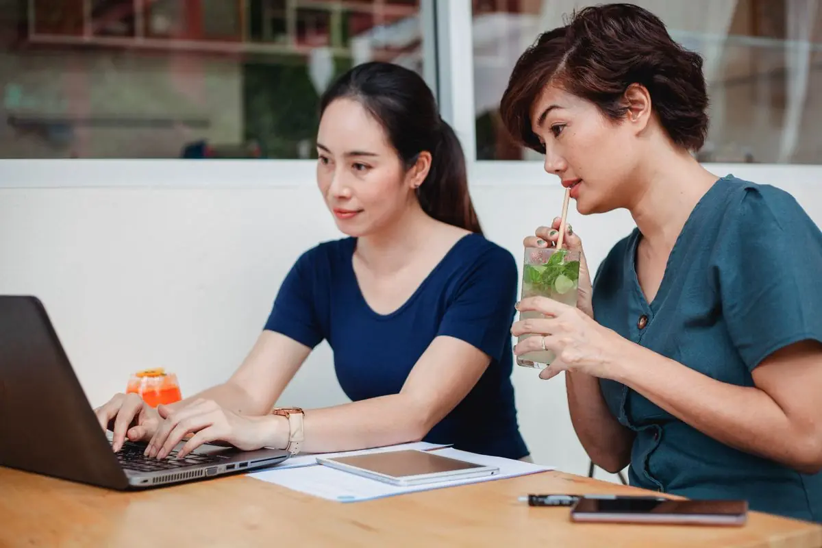 Hai người cùng học bên máy tính ở quán